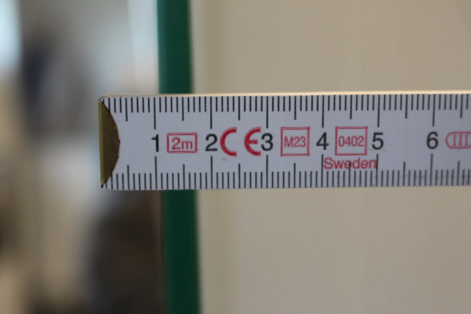 Die Glasstaerke einer Dusche wird mit einem Meterstab gemessen
