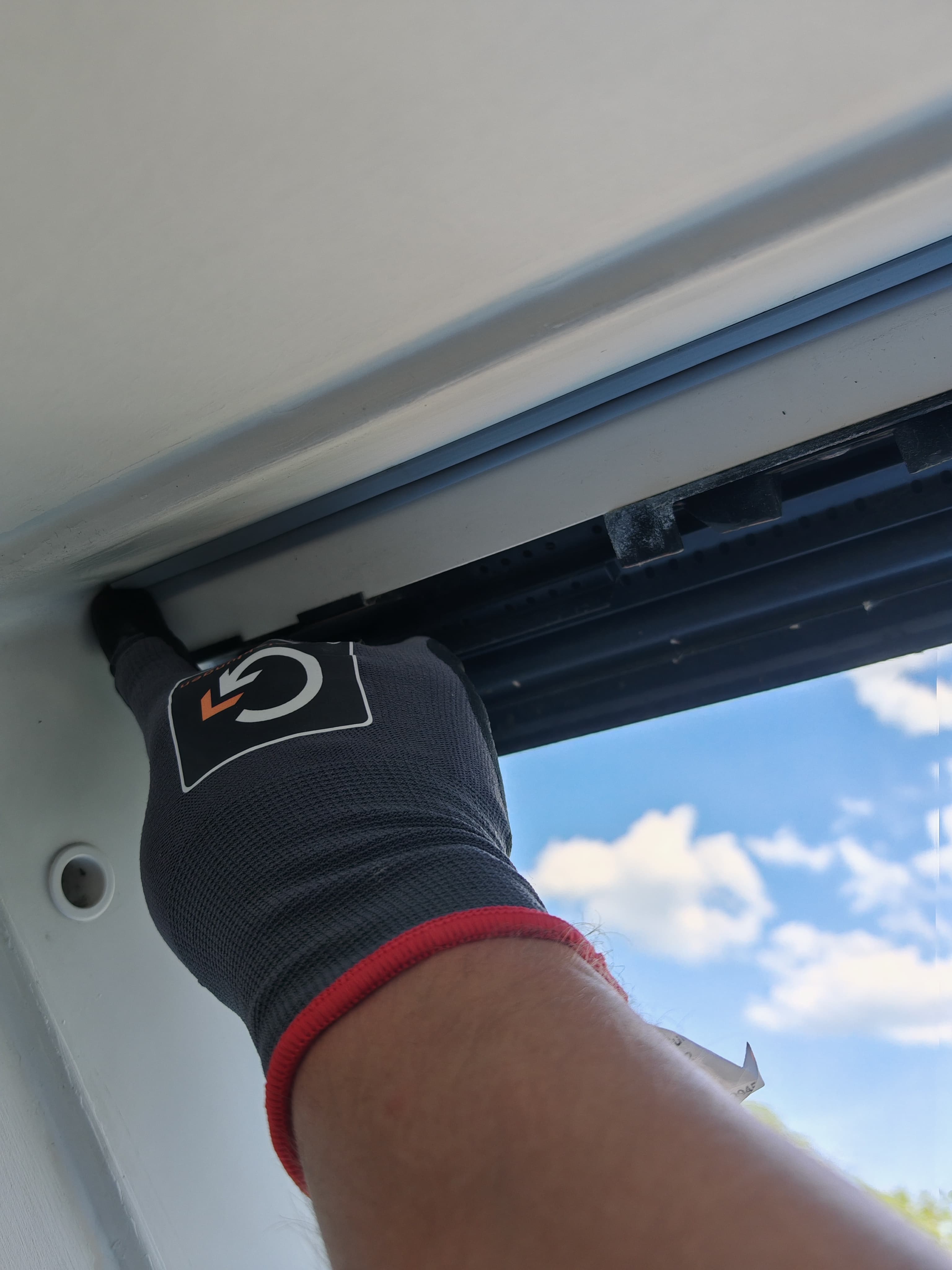 Mitarbeiter kontrolliert mit Graf-Grip Handschuhen die Dichtung vom Velux Dachfenster